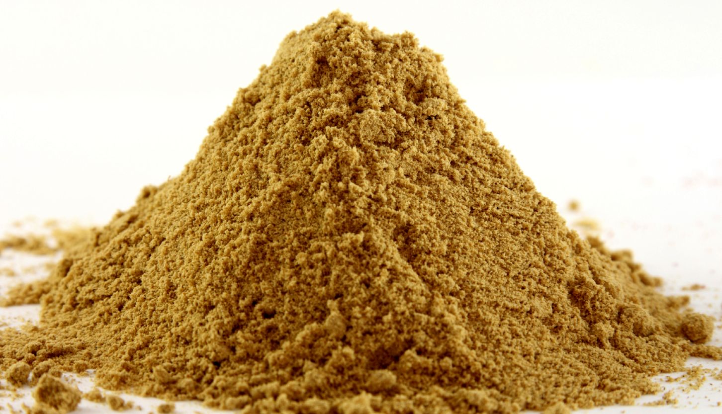 a pile of ground ginger on white, bright yellow color, sharp shot.